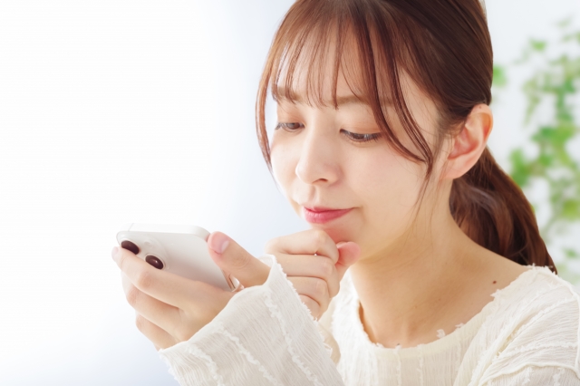 スマホを見る女性の画像