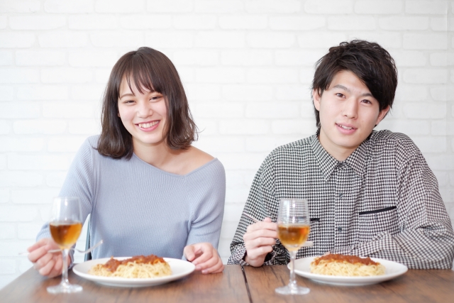 食事をするデート中のカップルの画像