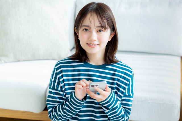 スマホを操作する女性の画像