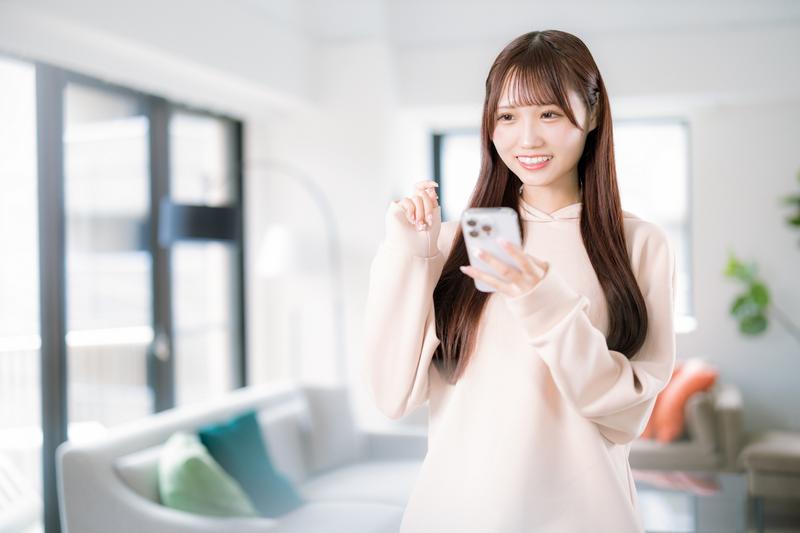 スマホを笑顔で操作する女性