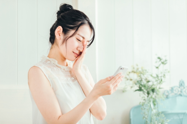 スマホを見て困った表情をしている女性