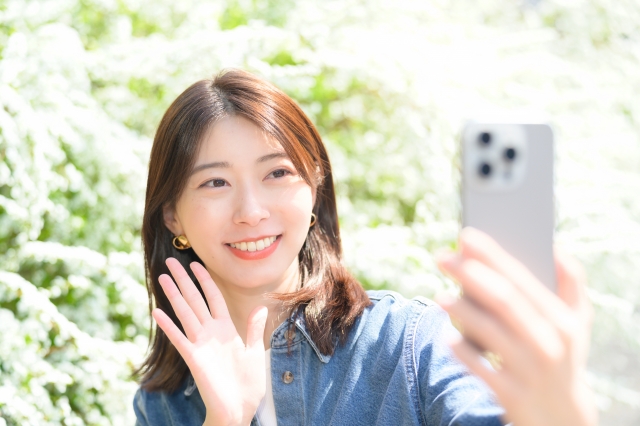 屋外で自撮りをする女性