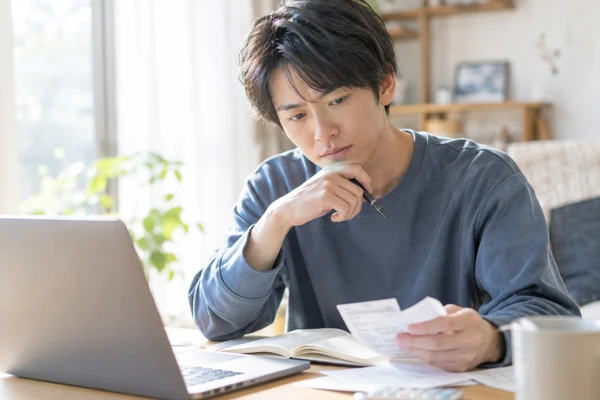 20代の男性が費用を見比べている