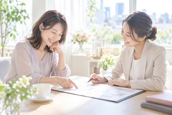 明るい相談室で、担当のアドバイザーと料金表を見ながらプランを選んでいる30代の女性