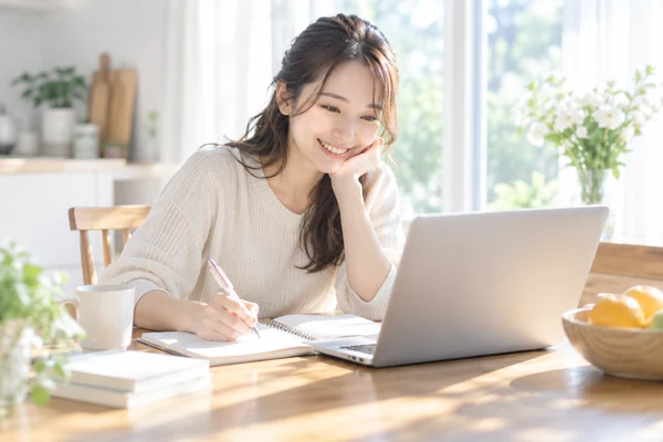 自宅のテーブルで、婚活の方法を書き出して見比べている20代の女性