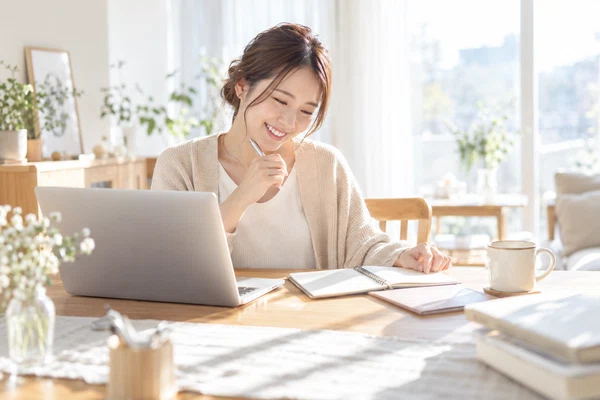 自宅のテーブルで、婚活の方法を書き出して見比べている30代の女性
