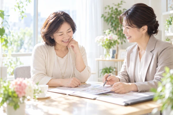 明るい相談室で、担当のアドバイザーに婚活の計画を相談している50代の女性