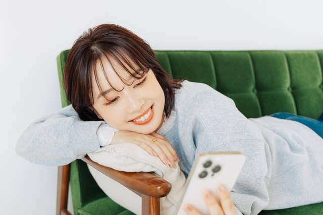 自分のペースでスマートフォンを見ながら婚活する女性